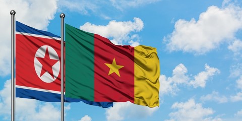 North Korea and Cameroon flag waving in the wind against white cloudy blue sky together. Diplomacy concept, international relations.