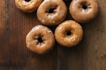 Overhead view of several glazed vanilla cake donuts. 