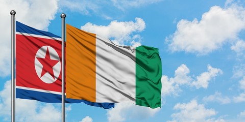 North Korea and Cote D'Ivoire flag waving in the wind against white cloudy blue sky together. Diplomacy concept, international relations.