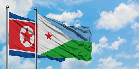 North Korea and Djibouti flag waving in the wind against white cloudy blue sky together. Diplomacy...