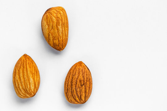 Three indole nuts without shells lie on the left on a white background, on the right - an empty place