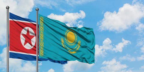 North Korea and Kazakhstan flag waving in the wind against white cloudy blue sky together. Diplomacy concept, international relations.
