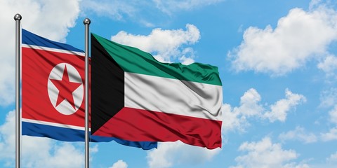 North Korea and Kuwait flag waving in the wind against white cloudy blue sky together. Diplomacy concept, international relations.