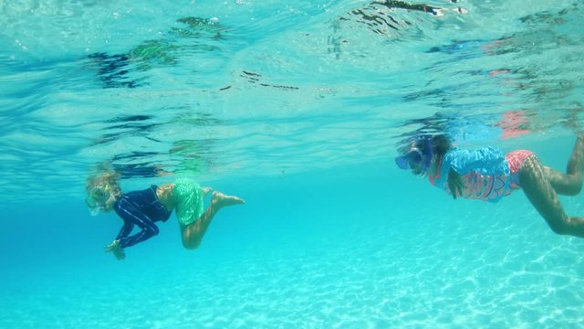 young boy and girl snorkelling in tropical water in the caribbean