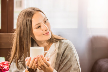 a girl in a cafe holding a mug of coffee