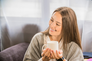 a girl in a cafe holding a mug of coffee