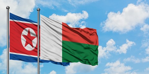 North Korea and Madagascar flag waving in the wind against white cloudy blue sky together. Diplomacy concept, international relations.