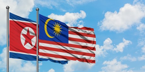 North Korea and Malaysia flag waving in the wind against white cloudy blue sky together. Diplomacy concept, international relations.