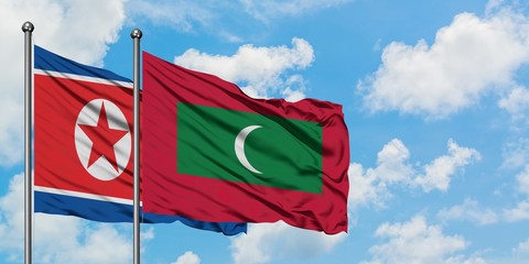 North Korea and Maldives flag waving in the wind against white cloudy blue sky together. Diplomacy concept, international relations.