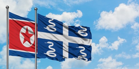 North Korea and Martinique flag waving in the wind against white cloudy blue sky together....