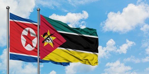 North Korea and Mozambique flag waving in the wind against white cloudy blue sky together. Diplomacy concept, international relations.