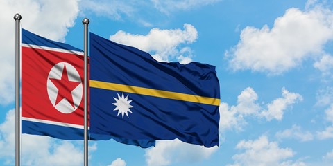 North Korea and Nauru flag waving in the wind against white cloudy blue sky together. Diplomacy...
