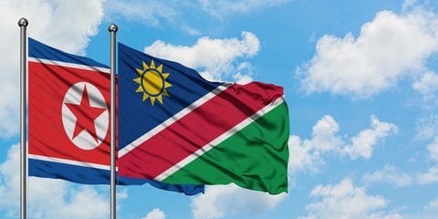 North Korea and Namibia flag waving in the wind against white cloudy blue sky together. Diplomacy concept, international relations.