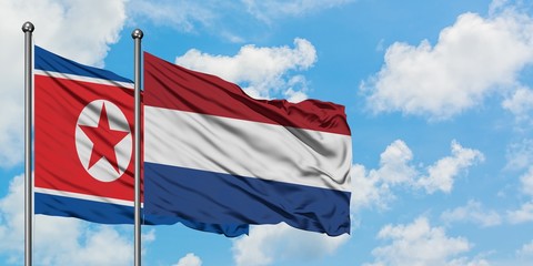 North Korea and Netherlands flag waving in the wind against white cloudy blue sky together. Diplomacy concept, international relations.