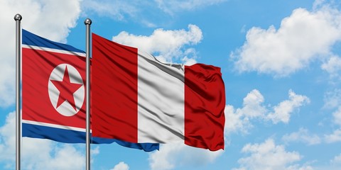 North Korea and Peru flag waving in the wind against white cloudy blue sky together. Diplomacy concept, international relations.