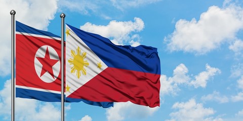 North Korea and Philippines flag waving in the wind against white cloudy blue sky together. Diplomacy concept, international relations.