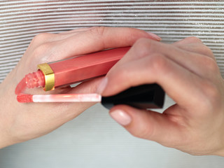 Woman's beauty blogger hands holding bottles and tubes spa professional hi-end cosmetics applies...
