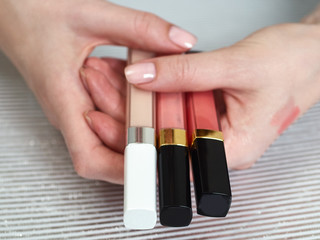 Woman's beauty blogger hands holding bottles and tubes spa professional hi-end cosmetics applies...