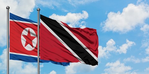 North Korea and Trinidad And Tobago flag waving in the wind against white cloudy blue sky together. Diplomacy concept, international relations.