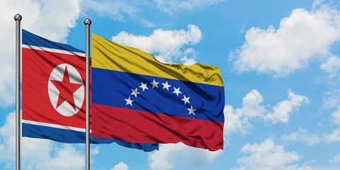 North Korea and Venezuela flag waving in the wind against white cloudy blue sky together. Diplomacy concept, international relations.