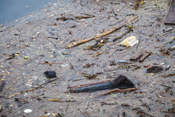 Contaminated, polluted water - river water surface with various waste and trash, nature pollution,...