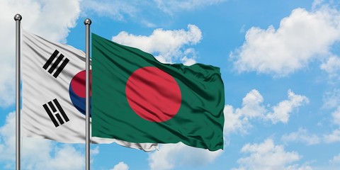 South Korea and Bangladesh flag waving in the wind against white cloudy blue sky together. Diplomacy concept, international relations.