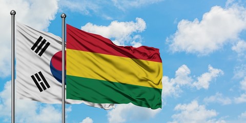 South Korea and Bolivia flag waving in the wind against white cloudy blue sky together. Diplomacy concept, international relations.