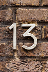 brass number 13 on brick wall