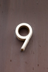brass number 9 on stone wall