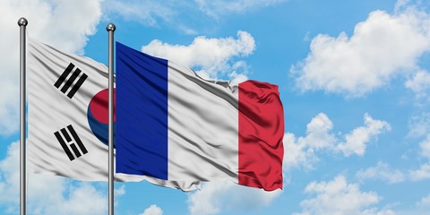 South Korea and France flag waving in the wind against white cloudy blue sky together. Diplomacy concept, international relations.