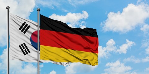 South Korea and Germany flag waving in the wind against white cloudy blue sky together. Diplomacy concept, international relations.