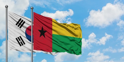 South Korea and Guinea Bissau flag waving in the wind against white cloudy blue sky together. Diplomacy concept, international relations.