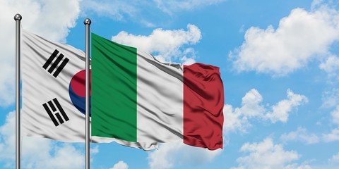 South Korea and Italy flag waving in the wind against white cloudy blue sky together. Diplomacy concept, international relations.