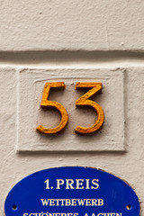 yellow number 53 on stone wall