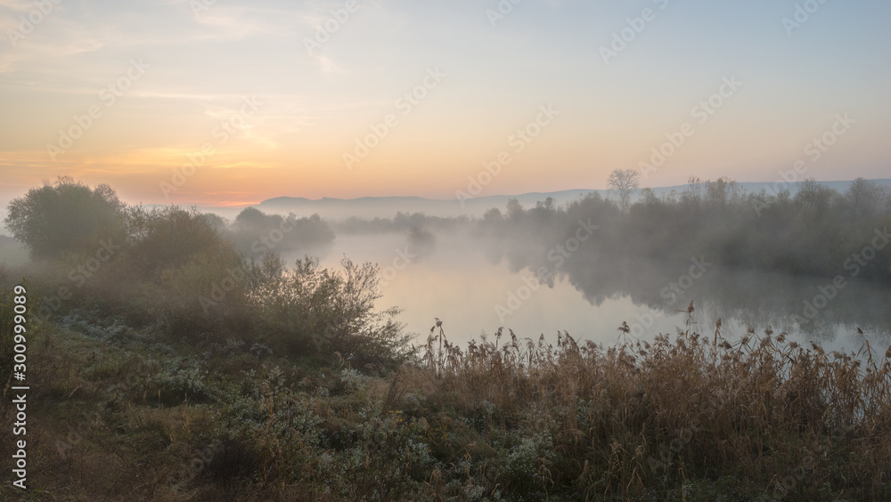 Wall mural Sunrise over the hills with fog over a river