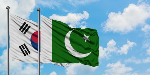South Korea and Pakistan flag waving in the wind against white cloudy blue sky together. Diplomacy...