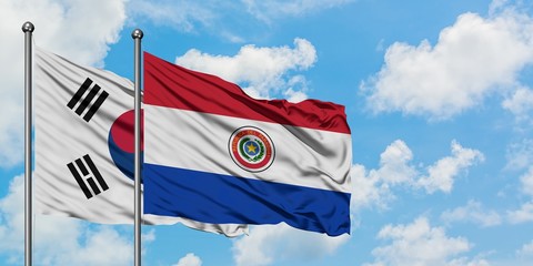 South Korea and Paraguay flag waving in the wind against white cloudy blue sky together. Diplomacy concept, international relations.