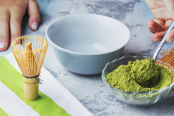 Girl puts matcha powder with a teaspoon. The process of making green tea.