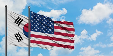 South Korea and United States flag waving in the wind against white cloudy blue sky together. Diplomacy concept, international relations.