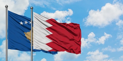Kosovo and Bahrain flag waving in the wind against white cloudy blue sky together. Diplomacy concept, international relations.
