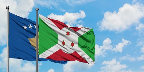Kosovo and Burundi flag waving in the wind against white cloudy blue sky together. Diplomacy...