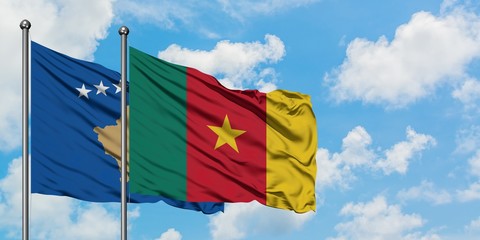 Kosovo and Cameroon flag waving in the wind against white cloudy blue sky together. Diplomacy concept, international relations.
