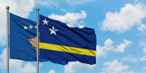 Kosovo and Curacao flag waving in the wind against white cloudy blue sky together. Diplomacy concept, international relations.