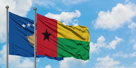 Kosovo and Guinea Bissau flag waving in the wind against white cloudy blue sky together. Diplomacy concept, international relations.