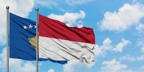 Kosovo and Indonesia flag waving in the wind against white cloudy blue sky together. Diplomacy...