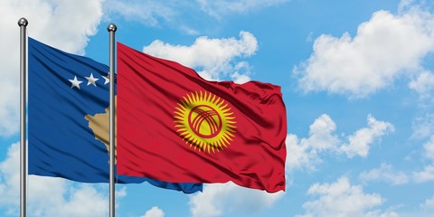 Kosovo and Kyrgyzstan flag waving in the wind against white cloudy blue sky together. Diplomacy...