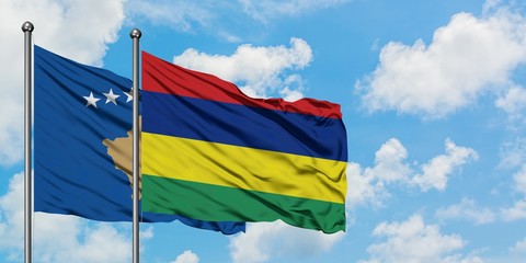 Kosovo and Mauritius flag waving in the wind against white cloudy blue sky together. Diplomacy concept, international relations.