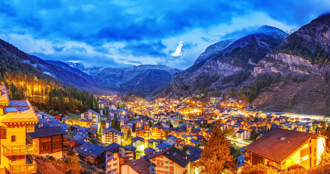 Beautiful panoramic view of Zermatt, famous and popular resort in Switzerland. Iconic mountain Matterhorn on background. Twilight scenery. Traditional mountain Swiss cityscape. Banner of Zermatt.