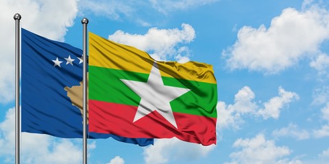 Kosovo and Myanmar flag waving in the wind against white cloudy blue sky together. Diplomacy...