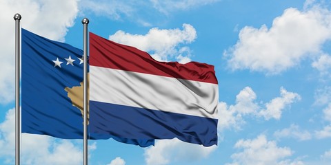 Kosovo and Netherlands flag waving in the wind against white cloudy blue sky together. Diplomacy concept, international relations.
